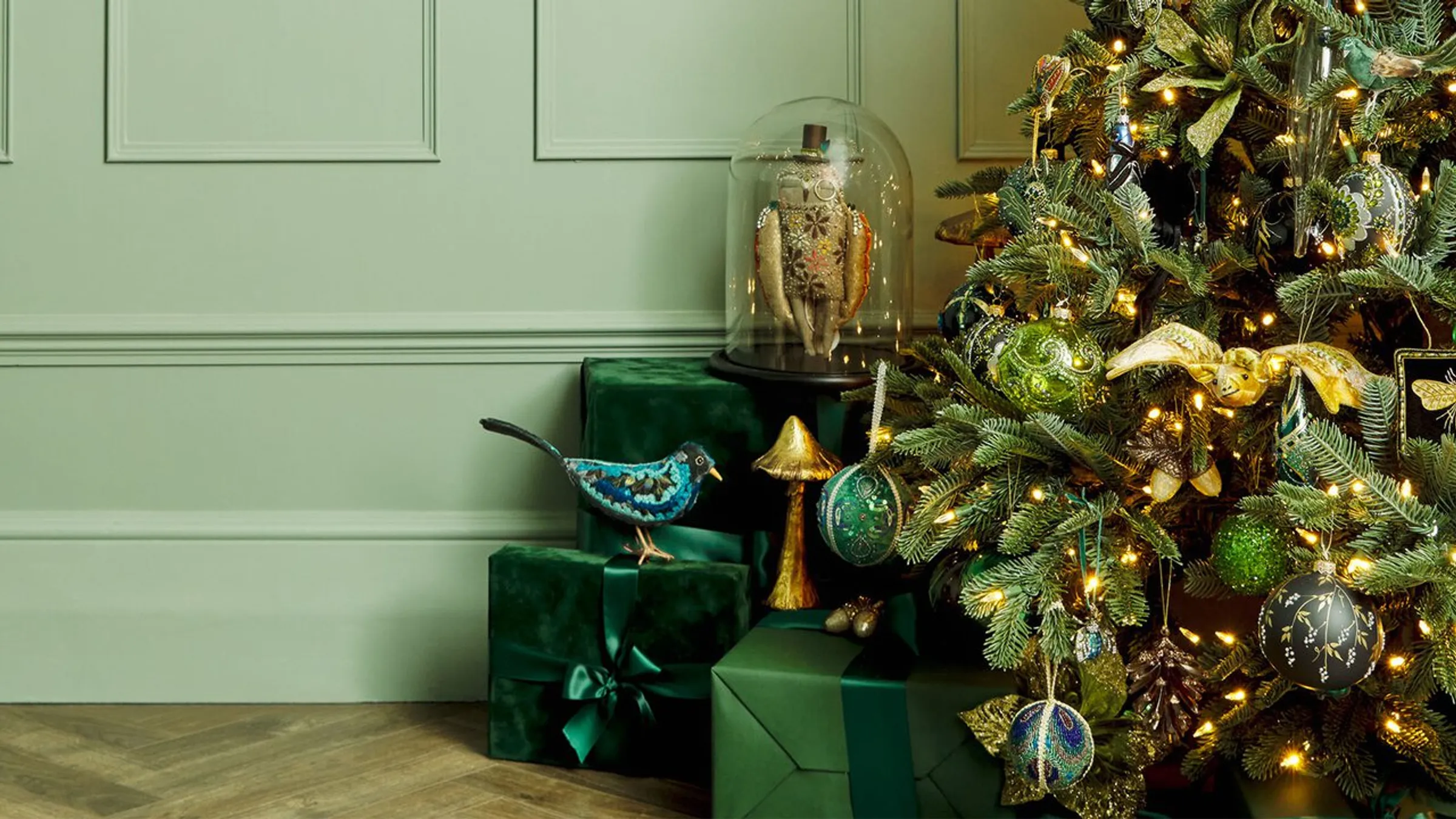 a christmas tree with presents under a glass dome