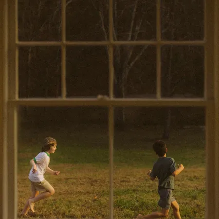 two boys running in a yard