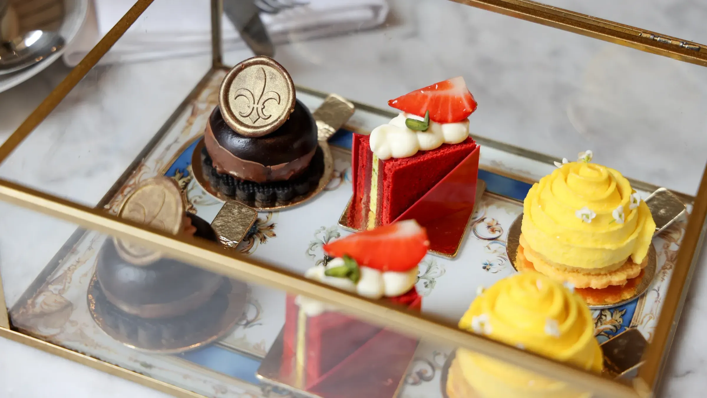 a tray of desserts in a glass case