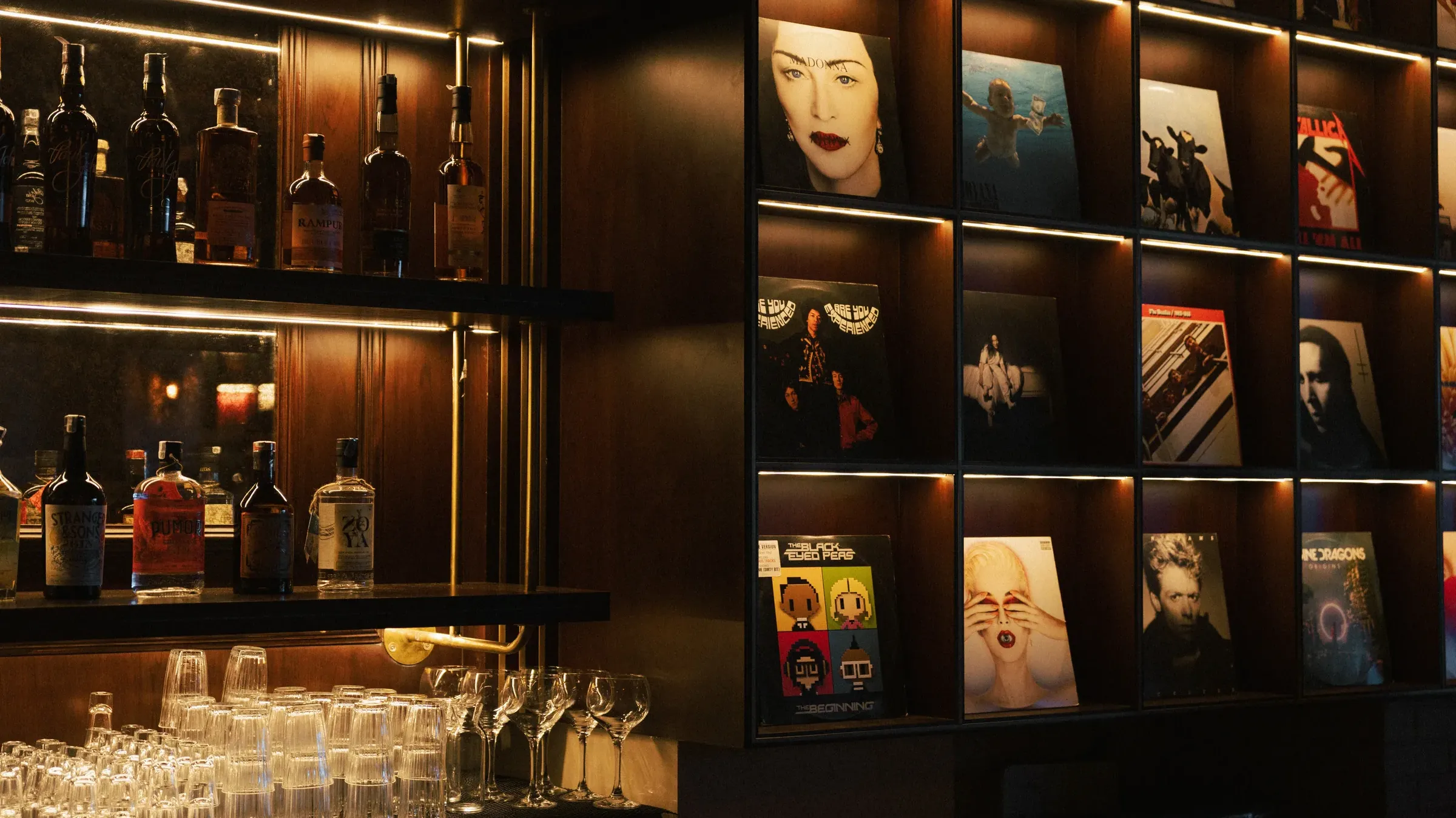 a shelf with liquor bottles and glasses