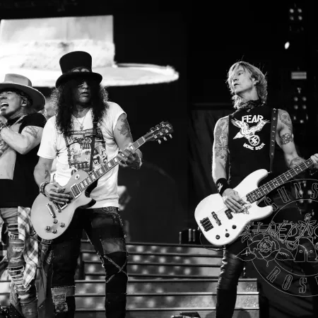 a group of men playing guitars on a stage
