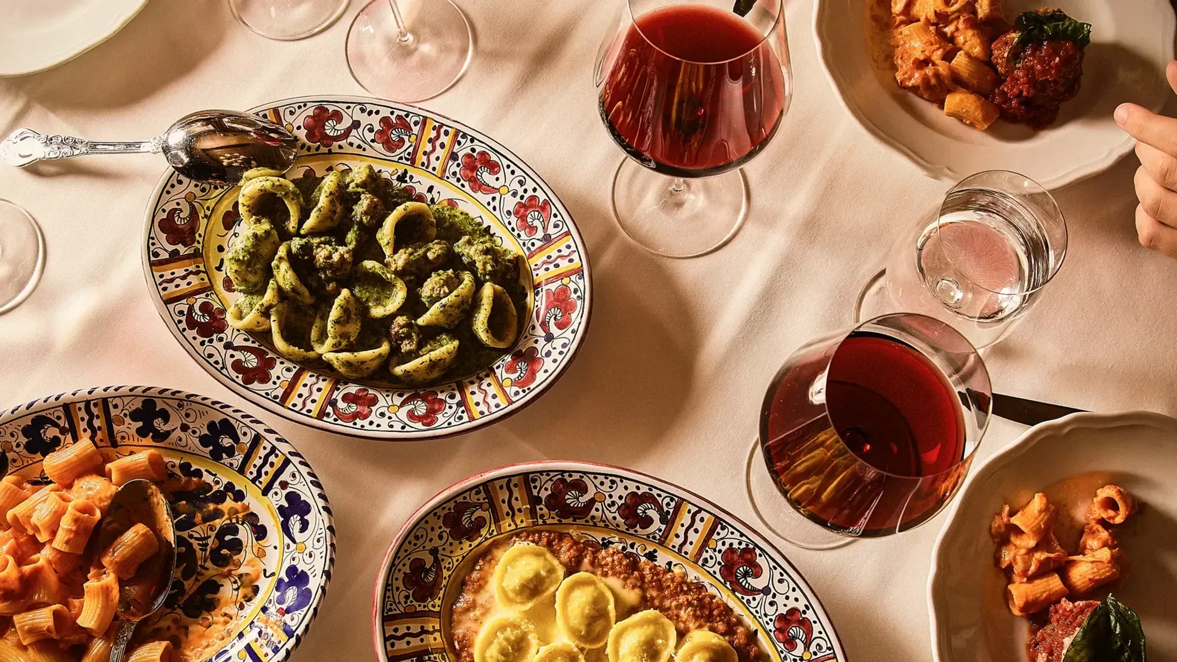 a table with plates of food and wine glasses