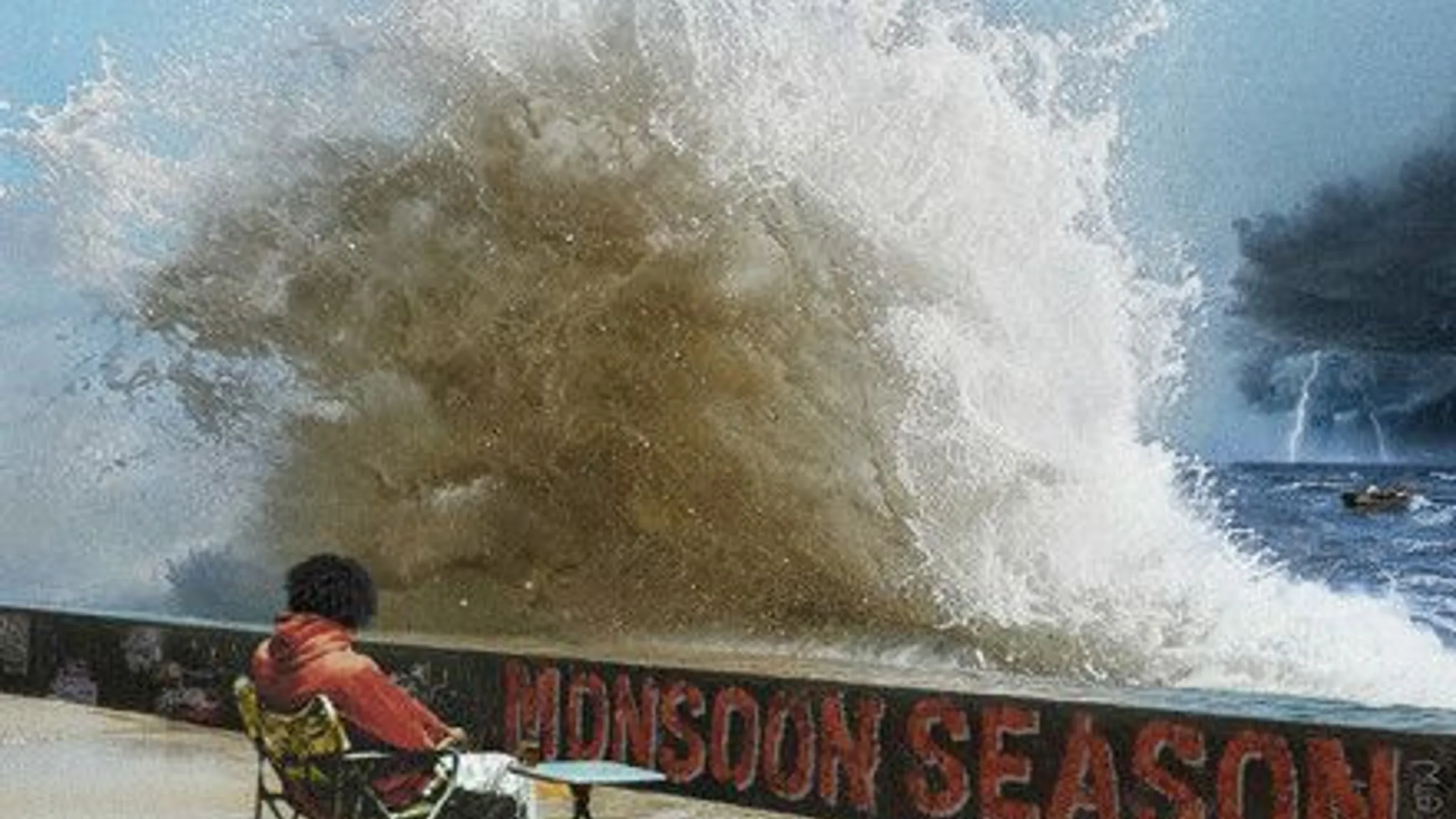 a person sitting in a chair by a wave