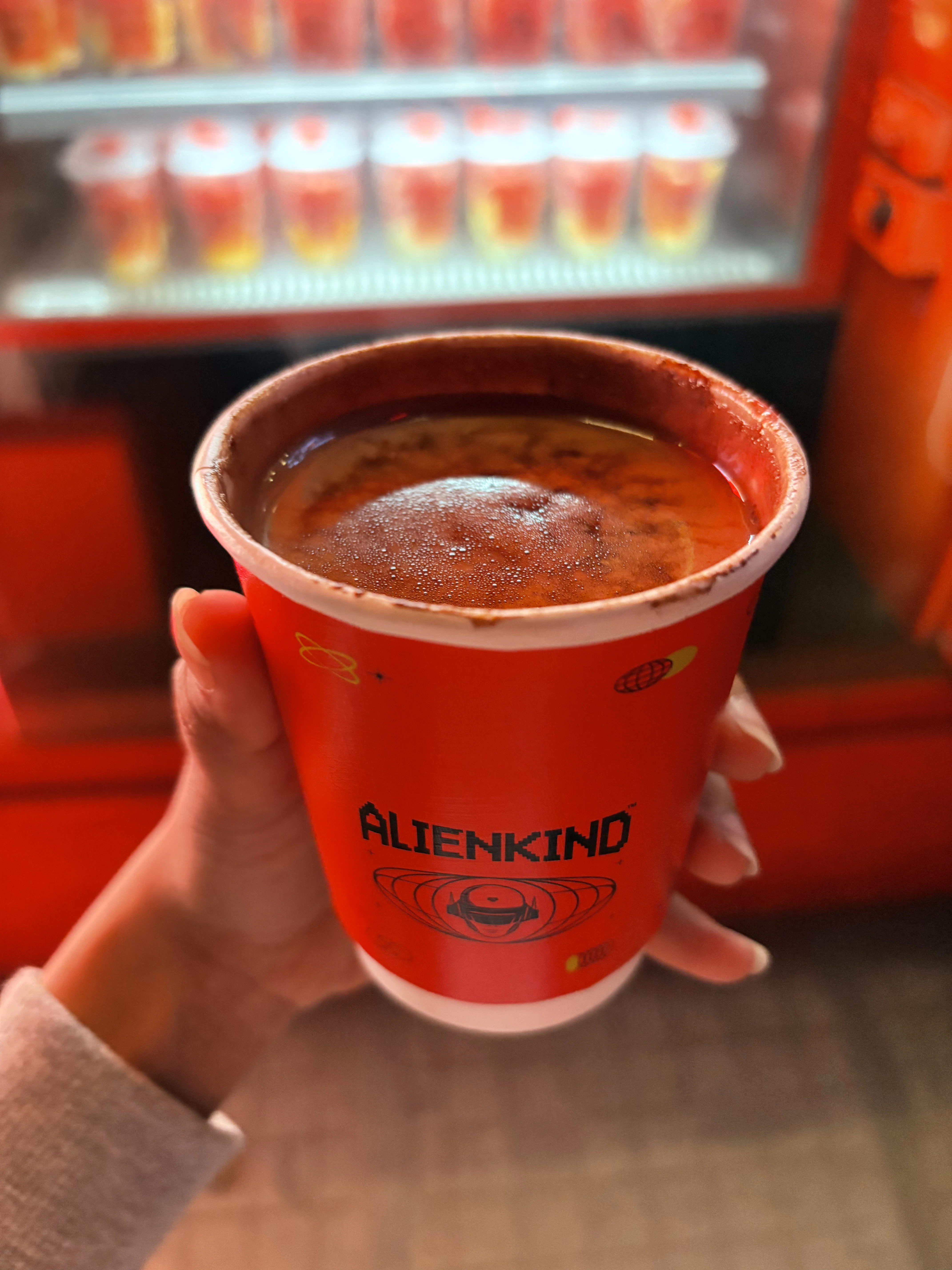 a hand holding a cup of hot drink