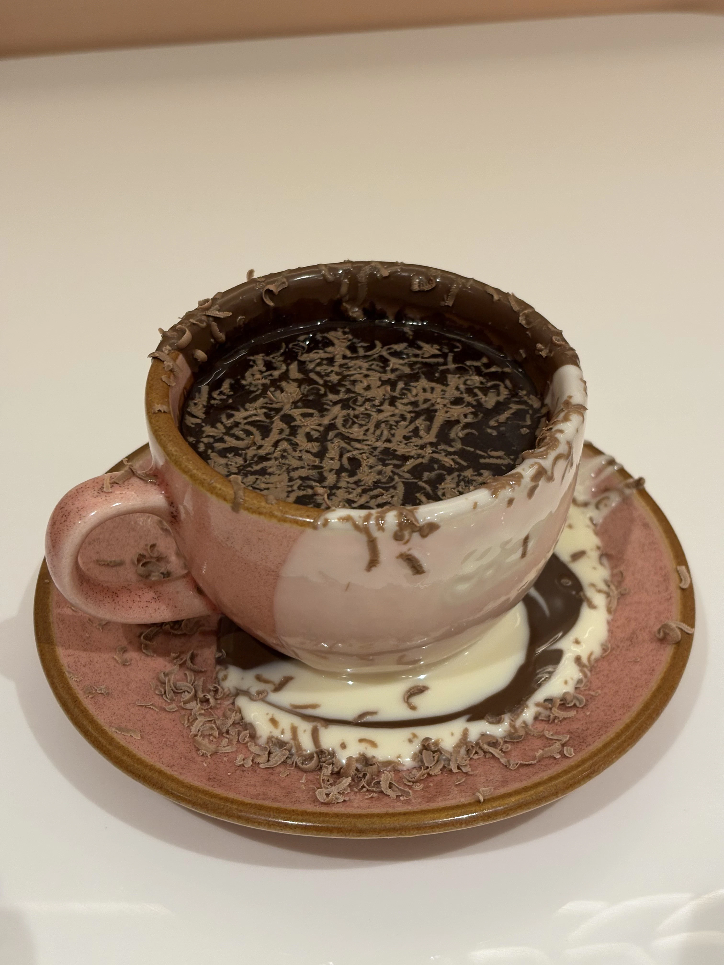 a cup of hot chocolate with chocolate shavings on a saucer
