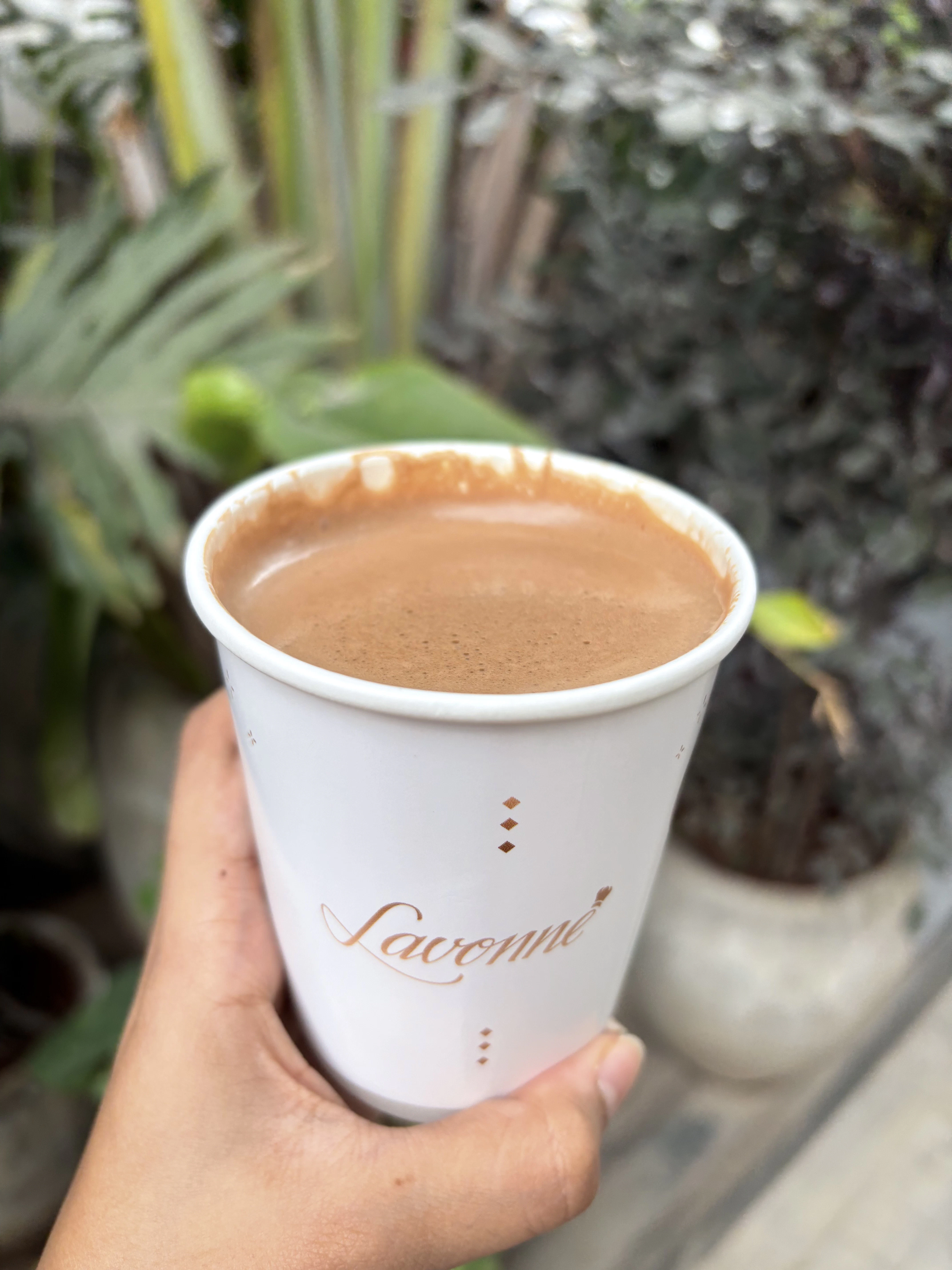 a hand holding a cup of coffee