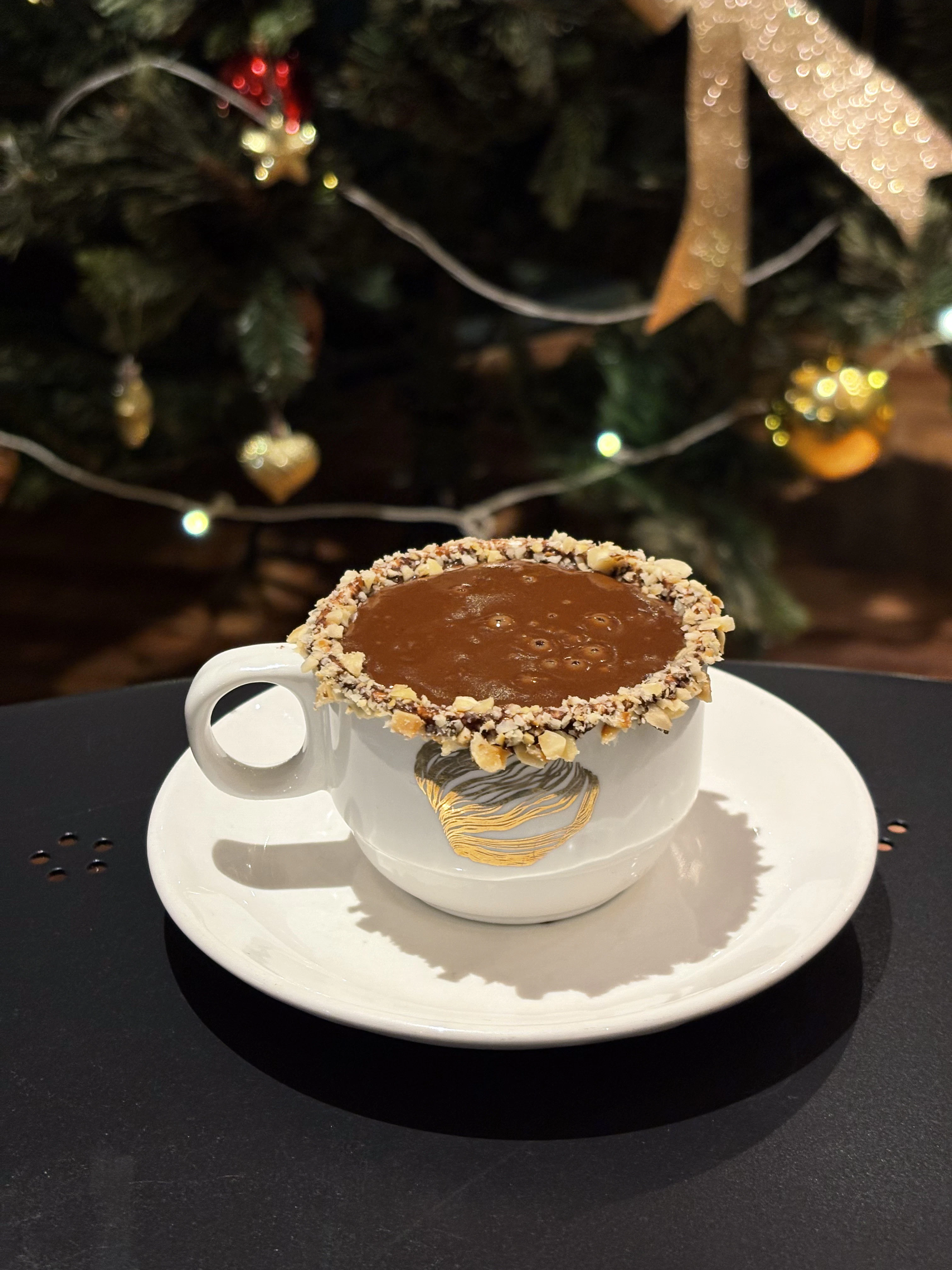 a cup of hot chocolate with nuts on top