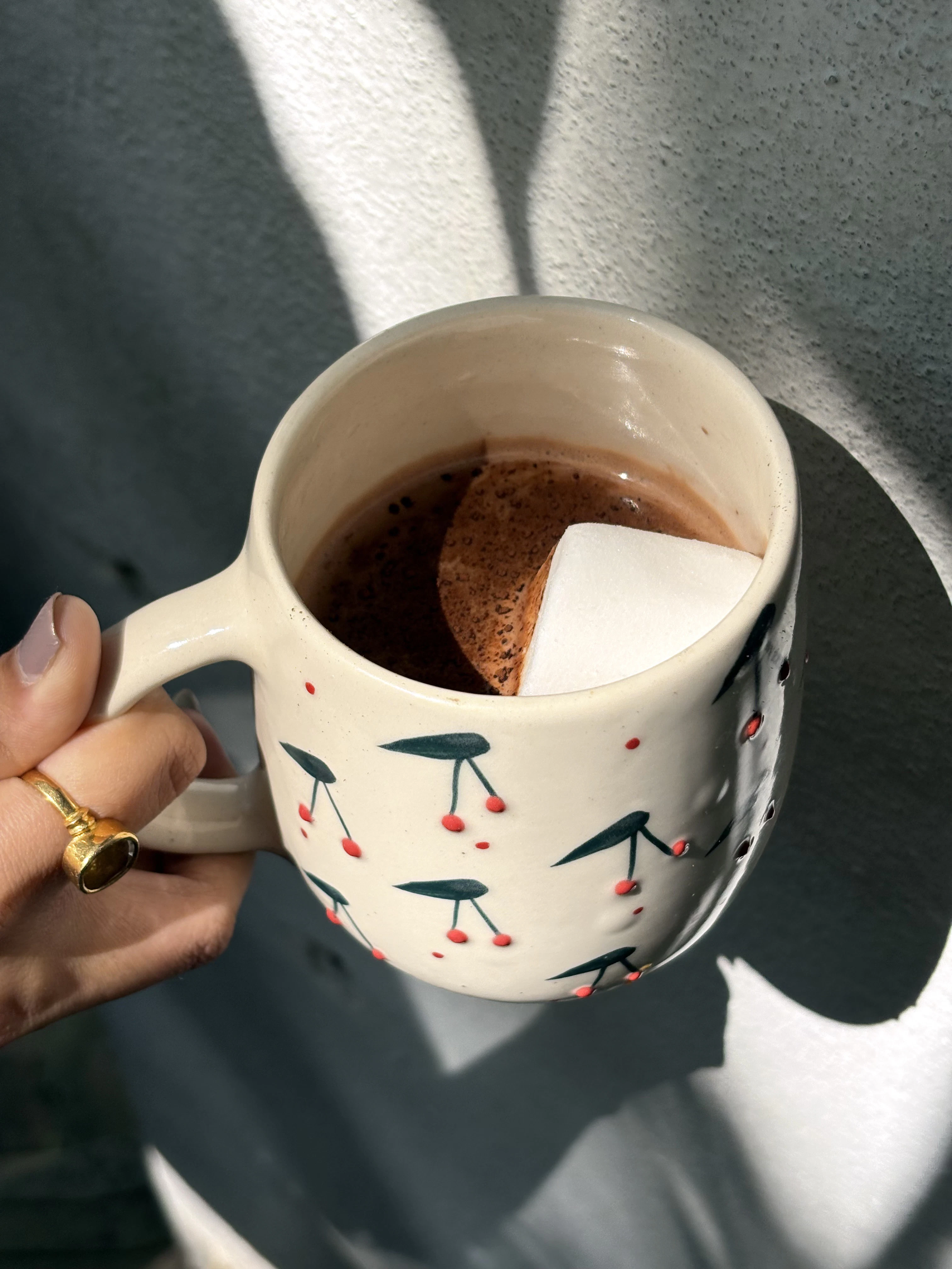 a hand holding a cup of hot chocolate