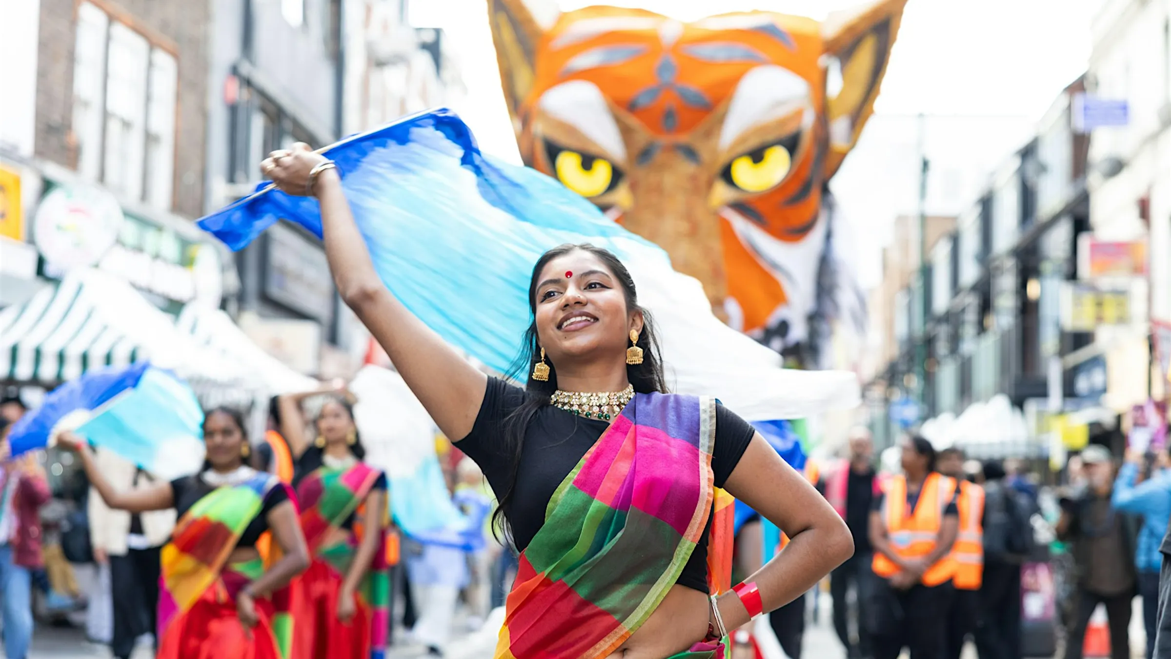 a woman in a colorful dress holding a flag