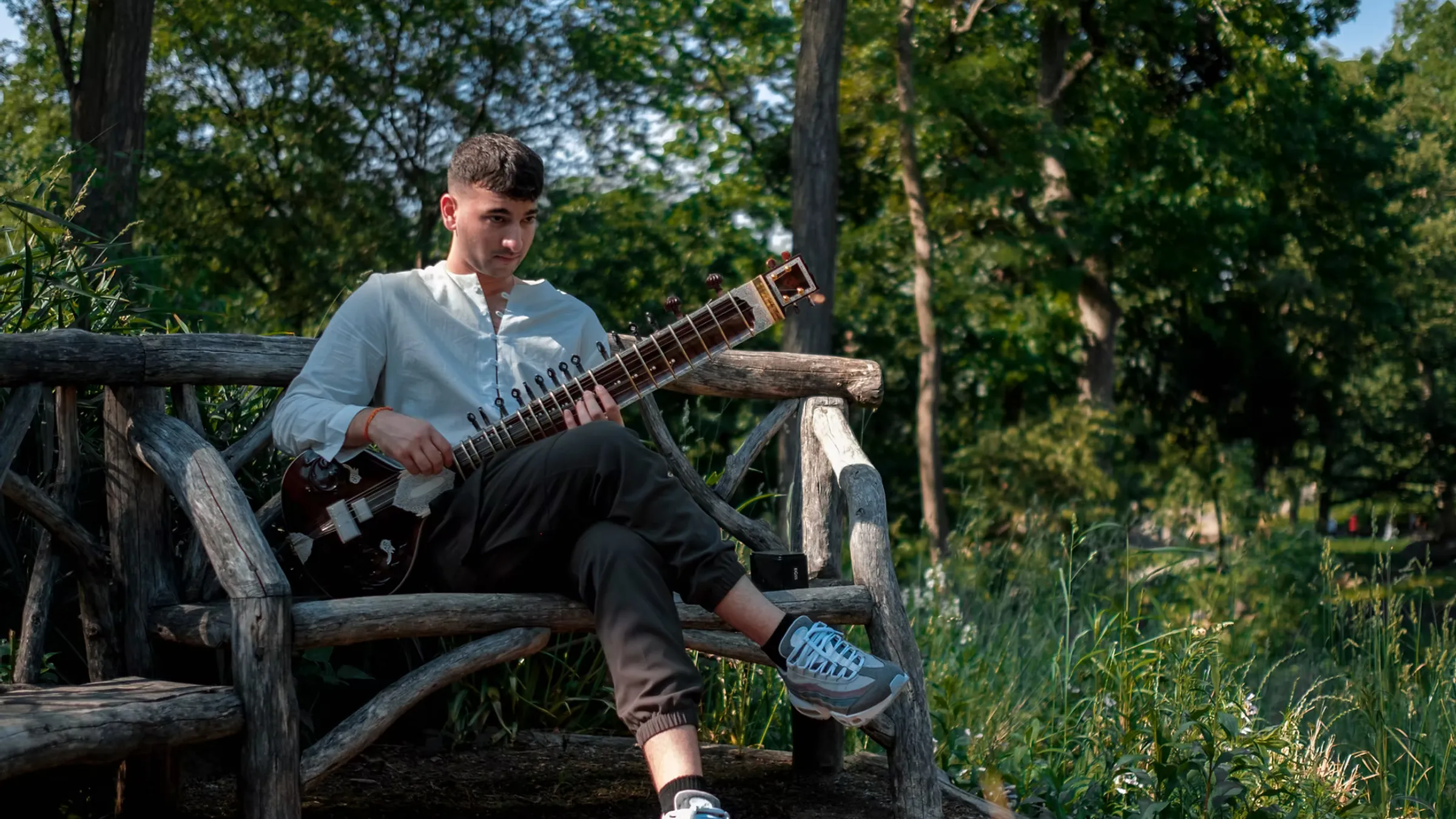 a man sitting on a bench playing a guitar